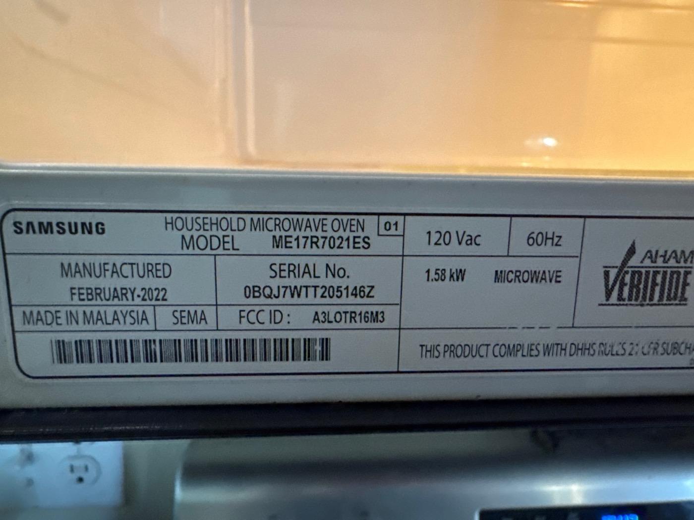 Manufacturer label inside a Samsung microwave showing model and serial number
